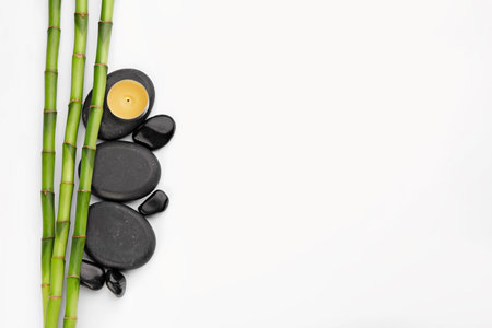 Spa stones, candle and bamboo stems on white background, top viewの写真素材