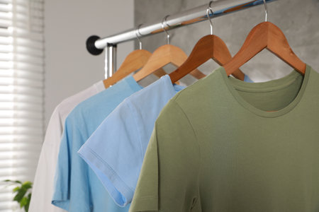 Clean T-shirts hanging on rack indoors, closeupの写真素材