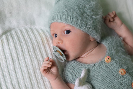 Cute newborn baby with pacifier on white blanketの写真素材