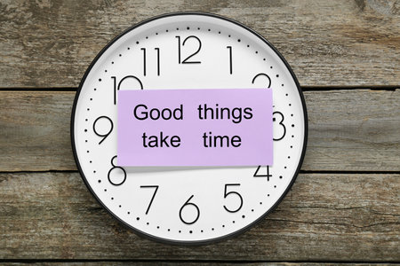 Phrase Good Things Take Time and clock on wooden table, top view. Motivational quoteの写真素材