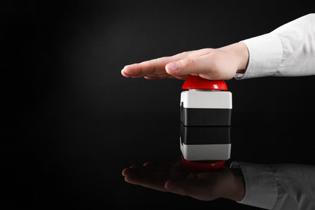 Man pressing red button of nuclear weapon on black background, closeup with space for text. War...