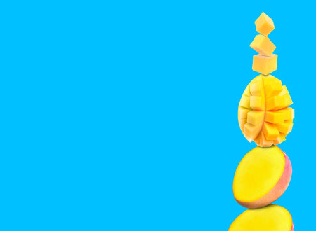 Stacked fresh mango fruits on light blue background, space for text