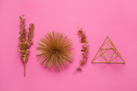 Flat lay composition with golden decor elements on pink backgroundの写真素材