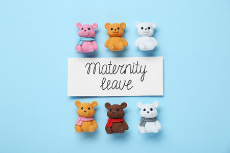 Card with phrase Maternity Leave and toys on light blue background, flat lay