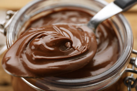 Glass jar and spoon of chocolate paste, closeupの写真素材