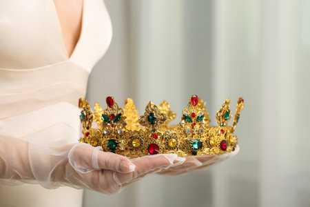 Bride holding luxurious crown on blurred background, closeup viewの写真素材