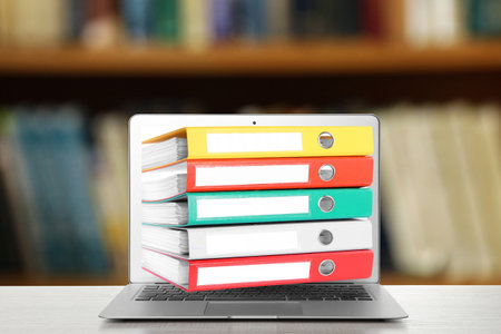 Store and organize information. Hardcover office folders getting out of modern laptop in archive roomの写真素材