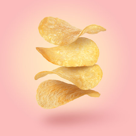 Stack of tasty potato chips falling on pink backgroundの写真素材