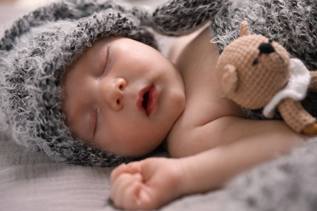 Cute newborn baby sleeping with teething toy in bed, closeupの写真素材