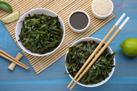 Fresh laminaria (kelp) seaweed served on light blue wooden table, flat layの写真素材