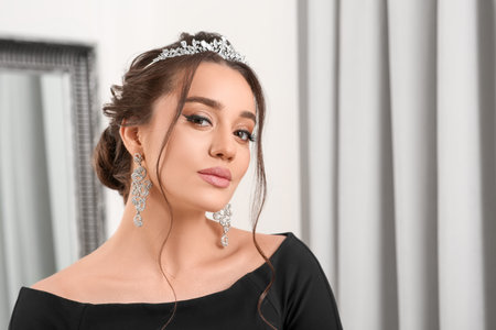 Beautiful young woman wearing luxurious tiara indoors, space for textの写真素材
