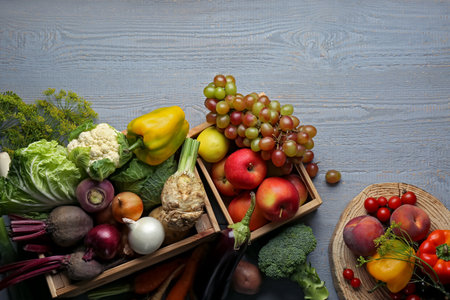 Different fresh vegetables and fruits in crates on gray wooden table, flat lay. farmer harvestingの写真素材