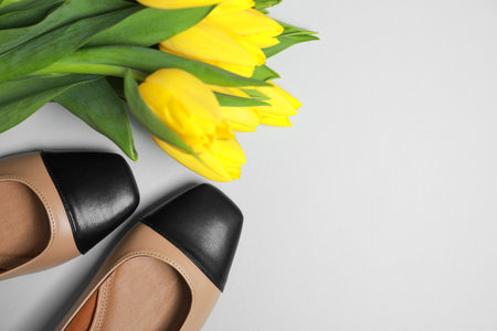 Pair of new stylish square toe ballet flats and beautiful tulips on light gray background, flat lay. Space for textの写真素材