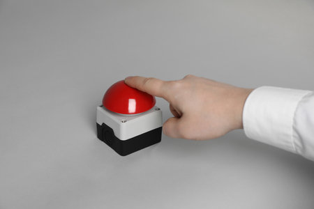 Man pressing red button of nuclear weapon on light gray background, closeup. War conceptの写真素材