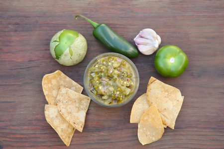 Tasty salsa sauce, ingredients and tortilla chips on wooden table, flat layの写真素材