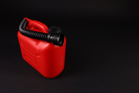 New red plastic canister on black background. Space for textの写真素材