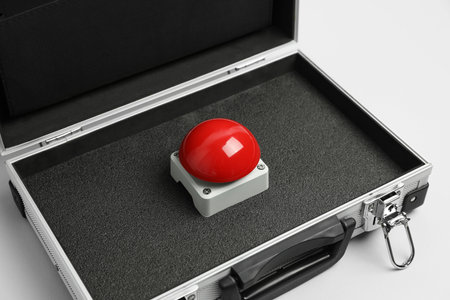 Red button of nuclear weapon in suitcase on white background. War concept