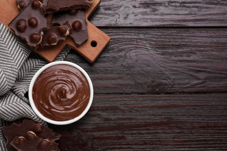 Bowl with tasty paste and pieces of chocolate on wooden table, flat lay. Space for textの写真素材