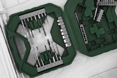 Set of replaceable drills on wooden floor, top view
