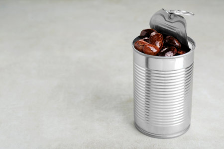 Tin can with kidney beans on light table, space for textの写真素材