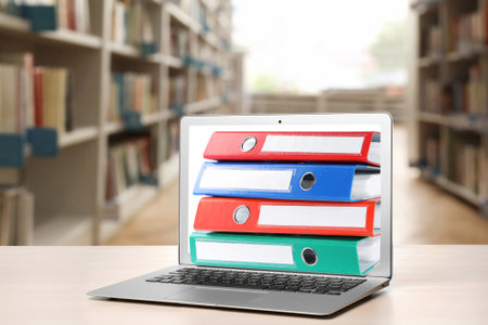 Store and organize information. Hardcover office folders getting out of modern laptop in archive roomの写真素材