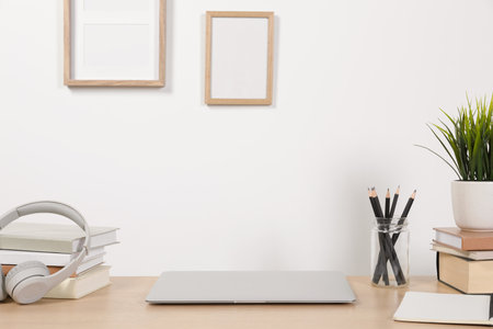 Cozy workspace with laptop and stationery on wooden desk at home