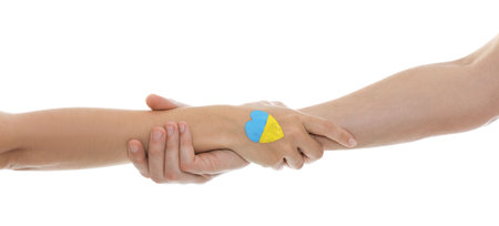 Man and woman with painted heart in colors of Ukrainian flag on her hand against white background,...