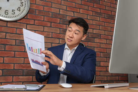 Boss having online meeting at wooden table in modern officeの写真素材
