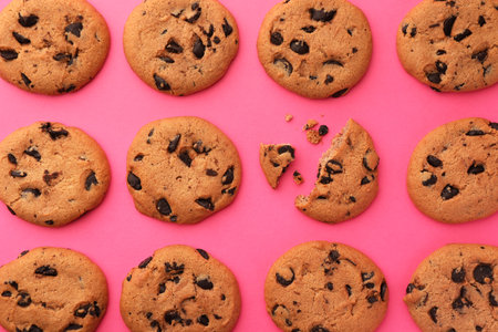 Many delicious chocolate chip cookies on pink background, flat layの写真素材