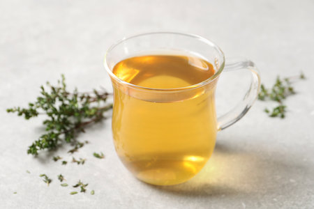 Aromatic herbal tea with thyme on light tableの写真素材