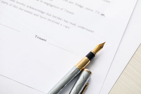 Fountain pen and documents on wooden table, above view. Notary servicesの写真素材
