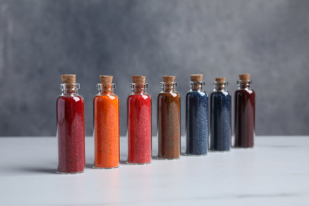 Glass bottles with different food coloring on white marble tableの写真素材