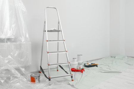 Metallic folding ladder and painting tools indoorsの写真素材