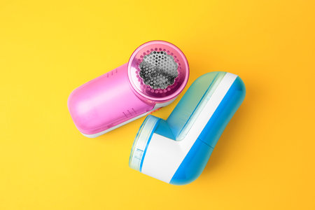 Modern fabric shavers on yellow background, flat layの写真素材