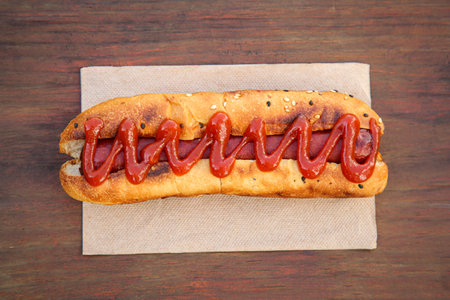 Fresh tasty hot dog with ketchup on wooden table, top viewの写真素材