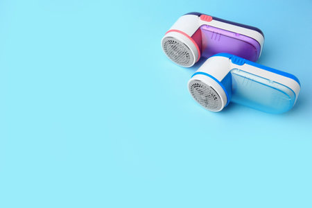 Modern fabric shavers on light blue background, above view. Space for textの写真素材