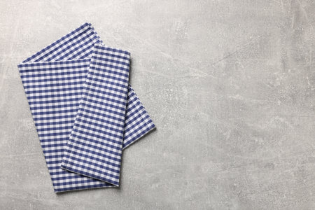 Blue checkered tablecloth on light gray textured table, top view. Space for textの写真素材
