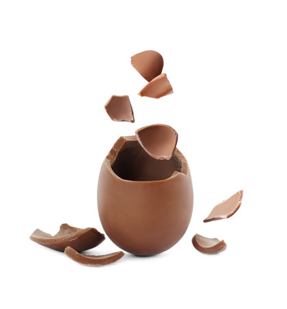 Exploded milk chocolate egg on white background