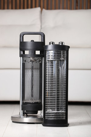 Different modern infrared heater on floor in cozy roomの写真素材