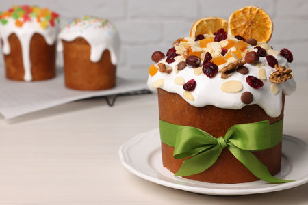 Tasty Easter cakes with dried fruits and nuts on white wooden table. Space for text