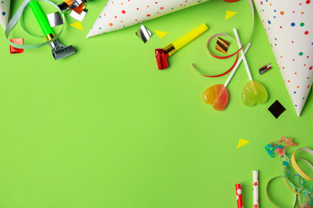 Colorful blowers, streamers and other festive decor on light green background, flat lay. Space for textの写真素材