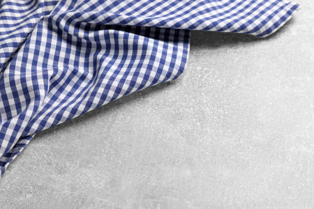 Blue checkered tablecloth on light gray textured table, space for textの写真素材