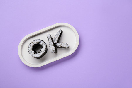 Word Ok made of sushi rolls on violet background, top view. Space for textの写真素材