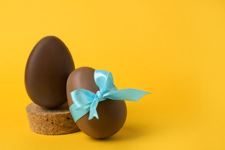 Tasty chocolate eggs on orange background. Space for textの写真素材