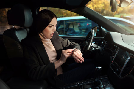 Emotional woman checking time on watch in car. Being late concept