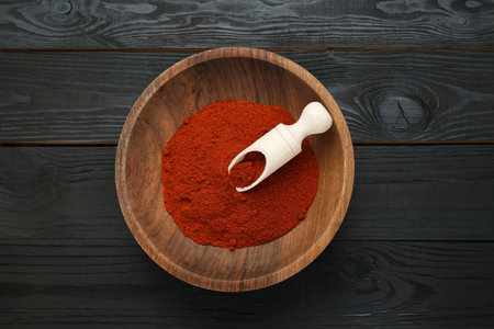 Bowl of aromatic paprika on black wooden table, top viewの写真素材