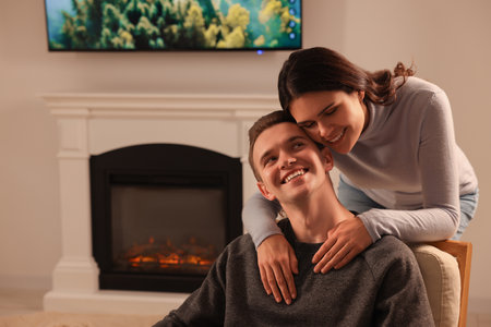 Happy lovely couple spending time together near fireplace at homeの写真素材