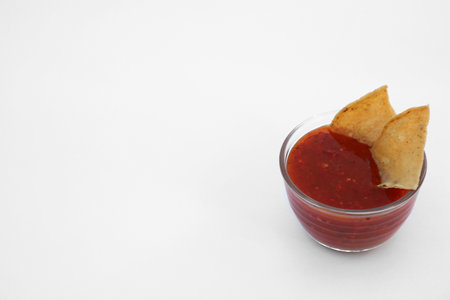 Tasty salsa sauce and tortilla chips on white backgroundの写真素材