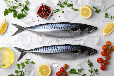 Raw mackerel, peppercorns and tomatoes on white table, flat layの写真素材