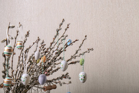 Beautiful willow branches with painted eggs on light gray background, space for text. easter decor
